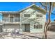 Two-story home features a two-car garage, balcony, and a lush, mature tree in the front yard at 401 Altamira Rd, Las Vegas, NV 89145