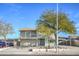 Two-story home features a two-car garage, balcony, and a lush, mature tree in the front yard at 401 Altamira Rd, Las Vegas, NV 89145