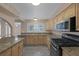 Kitchen featuring granite counters, wood cabinetry, and a range with stainless steel appliances for cooking at 401 Altamira Rd, Las Vegas, NV 89145