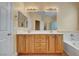 Bathroom featuring double vanity, bathtub and natural wood cabinets at 4593 Weitzman Pl, Las Vegas, NV 89141