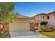 Charming single-Gathering home features an attached two-car garage with a brick-accented exterior and a well-manicured lawn at 4593 Weitzman Pl, Las Vegas, NV 89141