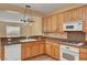 Kitchen with wooden cabinets, granite countertops, stainless steel appliances, and tile flooring at 4593 Weitzman Pl, Las Vegas, NV 89141