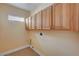 Practical laundry room with wooden cabinets for extra storage solutions at 4593 Weitzman Pl, Las Vegas, NV 89141