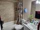 A well-lit bathroom with a combined shower-tub and updated vanity with tile walls at 4696 Krissylouise Way, Las Vegas, NV 89121