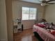 A cozy bedroom with natural light, laminated flooring, and a ceiling fan for added comfort at 4696 Krissylouise Way, Las Vegas, NV 89121