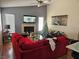 A spacious living room featuring a cozy fireplace, high ceilings, and comfortable red sofa with laminated flooring at 4696 Krissylouise Way, Las Vegas, NV 89121