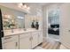 Bathroom with dual sinks, modern fixtures, a window, and a view into the bedroom at 4708 Mindful St, North Las Vegas, NV 89031