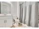 Well-lit bathroom with a vanity, toilet, and a shower featuring a gray curtain, offering a clean and functional space at 4708 Mindful St, North Las Vegas, NV 89031