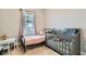 Bright bedroom with a window, a crib, and a small table, ideal for a Bedroom or young room at 4708 Mindful St, North Las Vegas, NV 89031