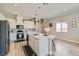 Modern kitchen features white cabinetry, stainless appliances, an island, and wood-look floors at 4708 Mindful St, North Las Vegas, NV 89031