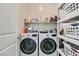 Functional laundry room with a side-by-side washer and dryer, shelves, and ample storage space for supplies at 4708 Mindful St, North Las Vegas, NV 89031