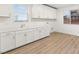 Bright laundry room with white cabinets, a sink, and wood-look tile flooring at 522 Riley Ridge Ct, Henderson, NV 89012