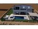 Backyard pool and patio featuring integrated spa, lounge chairs, outdoor kitchen, landscaping, and desert views at 522 Riley Ridge Ct, Henderson, NV 89012
