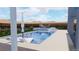 Modern backyard pool featuring integrated spa, lounge chairs, umbrella, patio furniture, and desert views at 522 Riley Ridge Ct, Henderson, NV 89012