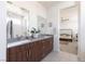 Bathroom features a double sink vanity with wood cabinets, with views into a bedroom, and bright natural light at 524 Grand Cascade Pl, North Las Vegas, NV 89084