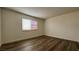 Bright bedroom featuring wood-look flooring, fresh paint, and a large window for natural light at 567 Roxella Ln # D, Las Vegas, NV 89110