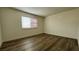 Bright bedroom featuring wood-look flooring, fresh paint, and a large window for natural light at 567 Roxella Ln # D, Las Vegas, NV 89110