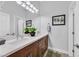 Bathroom featuring double sinks, wooden cabinets, and modern lighting fixtures at 6434 Spring Jog St, Las Vegas, NV 89166