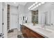Bathroom featuring double sinks, wooden cabinets, and a tiled walk-in shower at 6434 Spring Jog St, Las Vegas, NV 89166