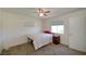 Bright bedroom featuring a ceiling fan, two windows, and neutral carpeting at 645 Utah St, Boulder City, NV 89005