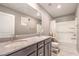 Bathroom featuring double sinks, dark wood cabinetry, a large mirror, and a shower/tub combination at 6904 Baylor Creek St, North Las Vegas, NV 89086