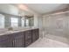 Modern bathroom featuring double sinks, dark wood cabinetry, and a glass-enclosed shower with a built-in bench at 6904 Baylor Creek St, North Las Vegas, NV 89086