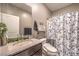 Updated bathroom featuring modern fixtures, sleek vanity, stylish mirror, and shower with decorative curtain at 6904 Baylor Creek St, North Las Vegas, NV 89086