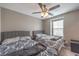 Bedroom featuring two beds with gray headboards, a ceiling fan, and a view of the houses outside the window at 6904 Baylor Creek St, North Las Vegas, NV 89086