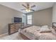 Bedroom featuring a ceiling fan, carpeted floors, a wooden dresser, and a queen-size bed at 6904 Baylor Creek St, North Las Vegas, NV 89086