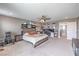 A bedroom with neutral walls, a ceiling fan, carpeted floors, and a large bed with a striped comforter at 6904 Baylor Creek St, North Las Vegas, NV 89086