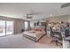 Bright bedroom with a ceiling fan, connected workstation, and large glass door leading to an outdoor patio at 6904 Baylor Creek St, North Las Vegas, NV 89086