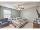Bedroom featuring a ceiling fan, a large window, a comfortable chair, and a dresser with a television at 6904 Baylor Creek St, North Las Vegas, NV 89086