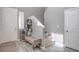 A bright entryway with neutral walls, gray floors, a bench, coat rack, and access to the staircase at 6904 Baylor Creek St, North Las Vegas, NV 89086