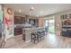 Open kitchen featuring stainless steel appliances, dark cabinets, granite countertops, a center island, and backyard access at 6904 Baylor Creek St, North Las Vegas, NV 89086