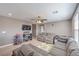 Upstairs living area featuring a gray sectional, neutral carpet, ceiling fan, and abundant natural light for versatile enjoyment at 6904 Baylor Creek St, North Las Vegas, NV 89086