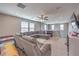 Upstairs living area featuring a large sectional, neutral carpet, ceiling fan, and natural light, perfect for relaxing and entertaining at 6904 Baylor Creek St, North Las Vegas, NV 89086