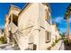 Exterior shot of a condo with stairs and tan stucco and an arched window at 7061 Roscoe Ave # 201, Las Vegas, NV 89129
