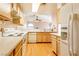 Bright kitchen features wood cabinets, white appliances, and white countertops, offering a clean and functional space at 7061 Roscoe Ave # 201, Las Vegas, NV 89129
