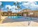 Community swimming pool and hot tub surrounded by palm trees and lounge chairs at 7061 Roscoe Ave # 201, Las Vegas, NV 89129
