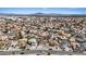 Wide aerial shot showcasing a neighborhood with many homes, some featuring pools, and mountain views in the background at 7138 Sixshooter Dr, Las Vegas, NV 89119