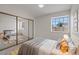 Staged bedroom with a large window, mirrored closet doors, and neutral décor at 7138 Sixshooter Dr, Las Vegas, NV 89119