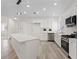 Bright kitchen features white cabinets, an island, and stainless steel appliances at 7138 Sixshooter Dr, Las Vegas, NV 89119