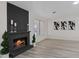 Bright living room boasts a brick fireplace, black accent wall, and decorative artwork at 7138 Sixshooter Dr, Las Vegas, NV 89119