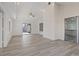 Open living room with vaulted ceilings, luxury vinyl floors, and sliding glass doors to backyard at 7138 Sixshooter Dr, Las Vegas, NV 89119