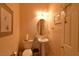 Neat powder room with pedestal sink, oval mirror, neutral paint and modern fixtures at 7325 Rustic Crest St, Las Vegas, NV 89149