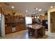 Spacious kitchen featuring custom cabinets, granite counters, and a large center island with seating at 7325 Rustic Crest St, Las Vegas, NV 89149