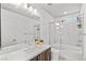 Bright bathroom featuring a large mirror, sleek vanity, and glass-enclosed shower/tub at 8116 Haywood Estate Ave, Las Vegas, NV 89113