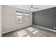 Bedroom features two windows, a ceiling fan and a gray accent wall at 8116 Haywood Estate Ave, Las Vegas, NV 89113
