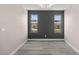 Neutrally decorated room with gray floors, accent wall, and large windows at 8116 Haywood Estate Ave, Las Vegas, NV 89113