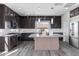 Modern kitchen with dark wood cabinetry, stainless steel appliances, and an island with bar seating at 8116 Haywood Estate Ave, Las Vegas, NV 89113